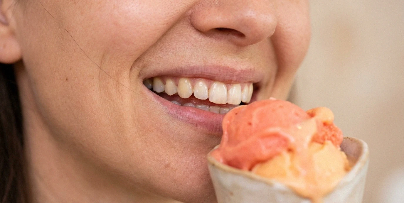 Primo piano di una donna sorridente con un gelato.